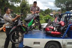 Petugas saat mengamankan motor yang ditumpangi korban laka.